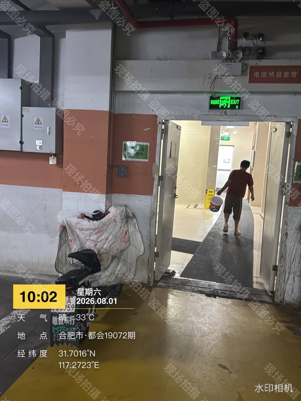 车库门口防火门敞开且电瓶车杂物堆放门口